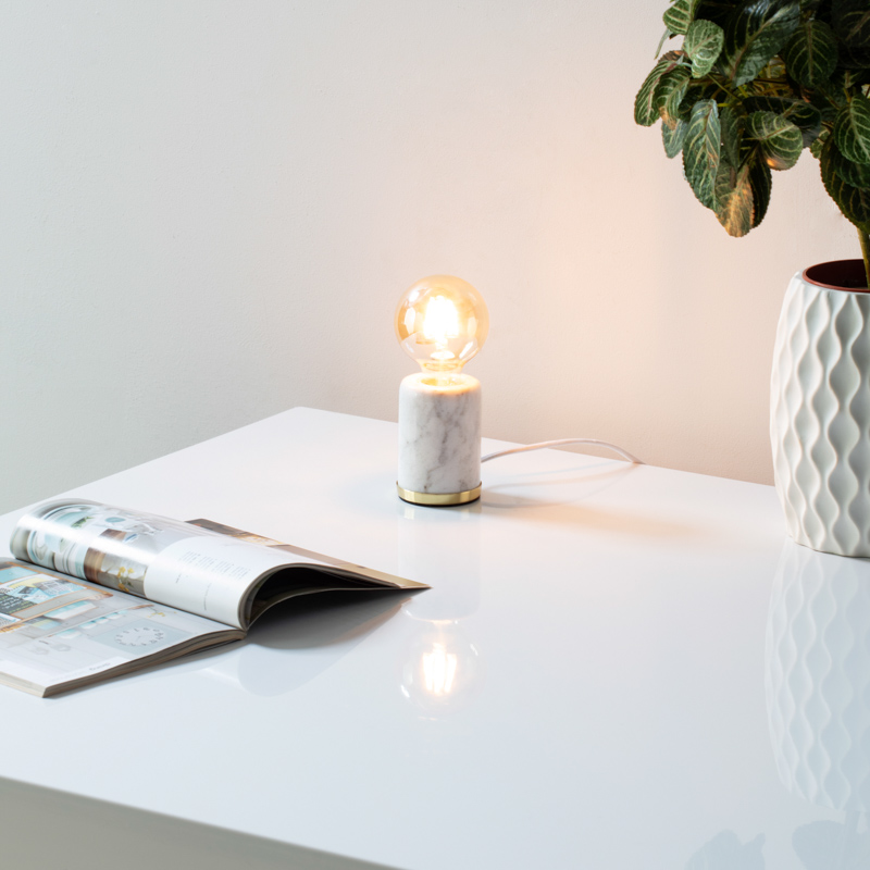 Small white, exposed bulb table lamp on a desk