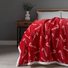 Christmas Candy Cane Throw with Sherpa Back, Red draped on foot of bed