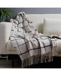 Plain Check Woven Throw, Natural & Blue draped over sofa against grey wall with plant
